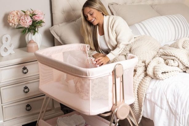 Baby bedside sleeper bassinet in pink with height adjustment and storage basket